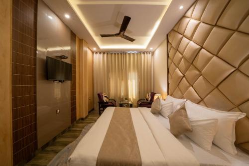 a bedroom with a large bed and a television at Perfectstayz Premium Ganga Heights - Ganga View rooftop cafe in Haridwār