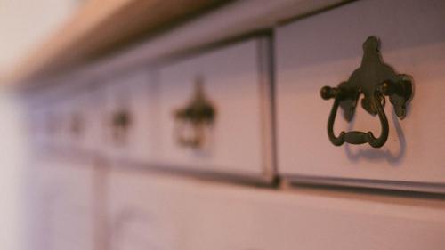 a row of white cabinets on a wall at Zöldre Néző Vendégház in Letkés