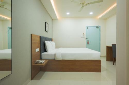 a hotel room with two beds and a mirror at Stae Hotel-Gachibowli in Hyderabad