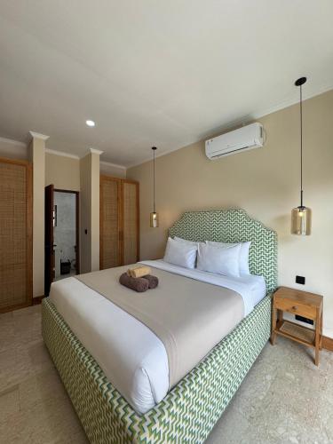 een slaapkamer met een groot wit bed en een deken bij Regina Suite in Bingin Beach