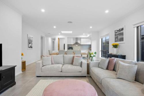 una sala de estar con 2 sofás blancos y una alfombra rosa en Hathaway Haven, en Alfredton