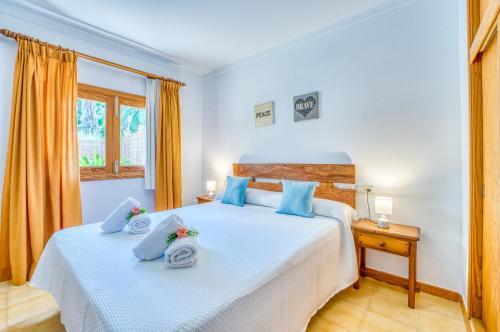 a bedroom with two beds with blue pillows at Ideal Property Mallorca - Eden Lago in Alcudia