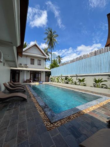 a swimming pool in front of a house at Maison Lake View Luang Prabang in Luang Prabang