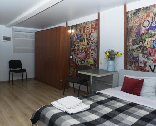 a bedroom with a bed and a table with chairs at Студія в 5 хв від залізничного вокзалу in Kharkiv