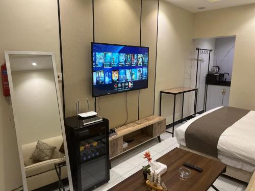 Zimmer mit einem Bett und einem Flachbild-TV in der Unterkunft Hala 04 استديو انيق ومستقل in Quai