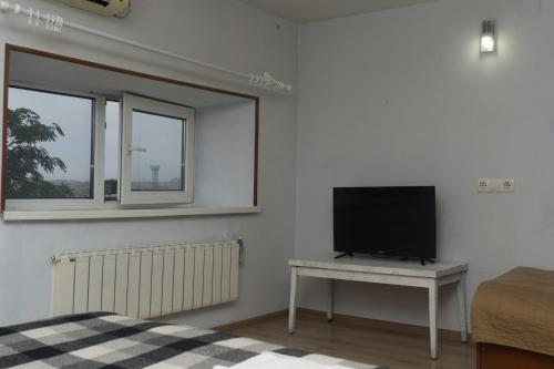a bedroom with a television and a table with a tv at Студія в 5 хв від залізничного вокзалу in Kharkiv