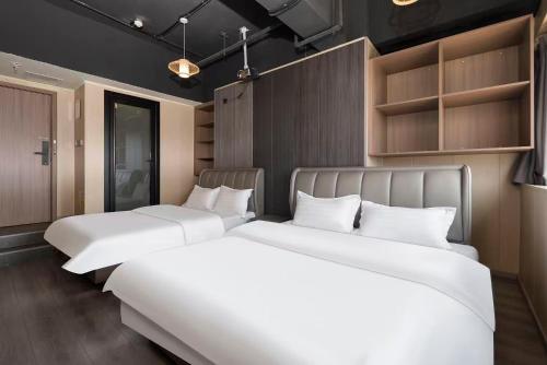 a row of three beds in a room at Shanpanyisu Hotel in Chongqing