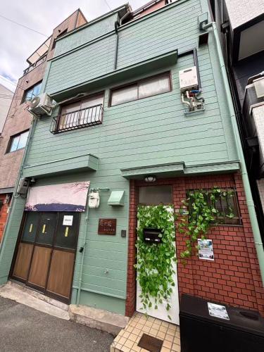 a green house with a green door on a street at 青の居 直达Usj 直达港区海游馆 可停车 in Osaka