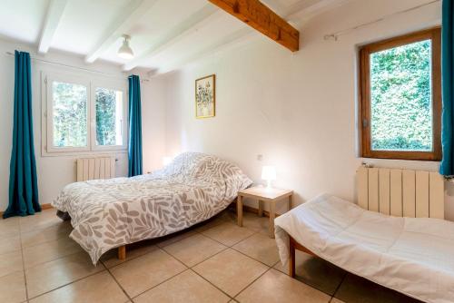 Un dormitorio con dos camas y dos ventanas. en Maisonnette Provençale, en Le Thor