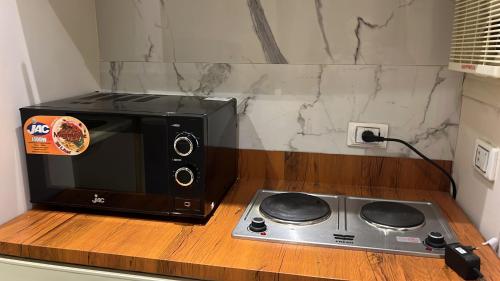 a microwave sitting on a counter next to a stove at ستديو فاخر بحدائق الاهرام in Ghaţāţī