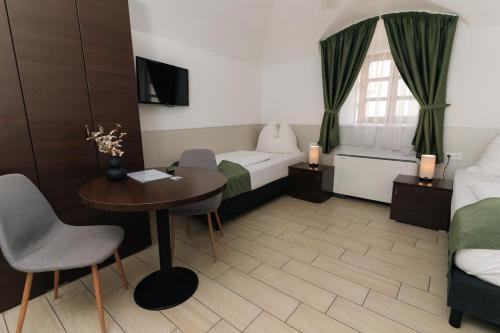 a hotel room with a desk and a bed and a table at River Apartmanház in Jászberény
