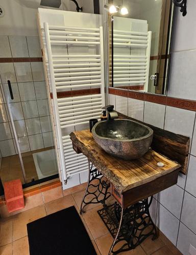 a bathroom with a stone sink on a wooden table at Chambre d'hôtes et de charme "Au Clos des Ammonites chez Ange&Sébastien " in Labeaume