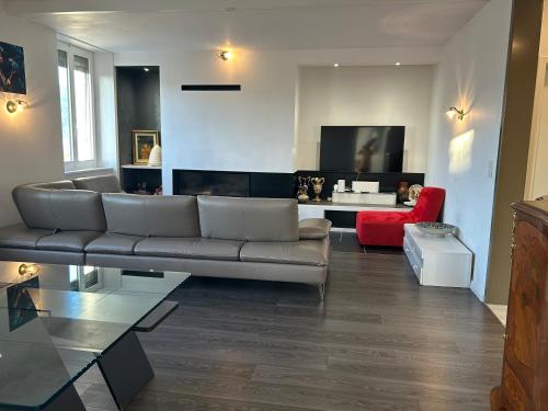 a living room with a couch and a red chair at Maison de Maître in Tramelan