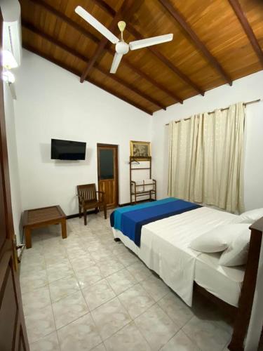 a bedroom with a bed and a ceiling fan at Villa Begonia in Kandy