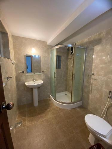 a bathroom with a shower and a sink and a toilet at Villa Begonia in Kandy