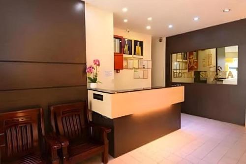 a lobby with a bar with two chairs and a counter at Hotel Sarina in Mukah