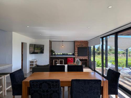 een eetkamer en woonkamer met een tafel en stoelen bij EersteBosch Cottages in Stellenbosch