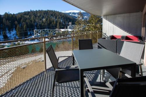 a table and chairs on a balcony with a view at Exklusive Ferienwohnung Im Hotel Mit Wellness in Laax