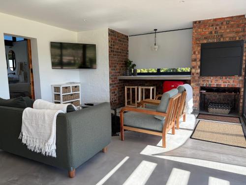 een woonkamer met twee banken en een open haard bij EersteBosch Cottages in Stellenbosch