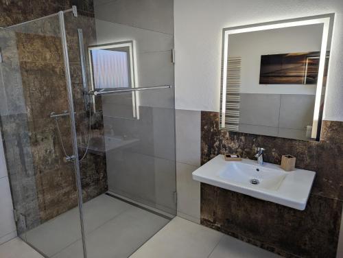 un baño con lavabo y ducha en Ferienwohnungen Bella Vita, en Harthausen