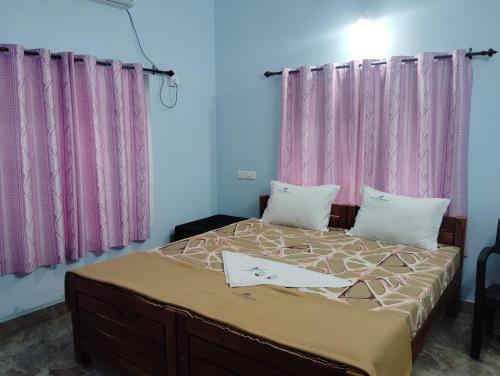 バルカラにあるShalimar Residencyのベッドルーム1室(ピンクのカーテンが付いた大型ベッド1台付)