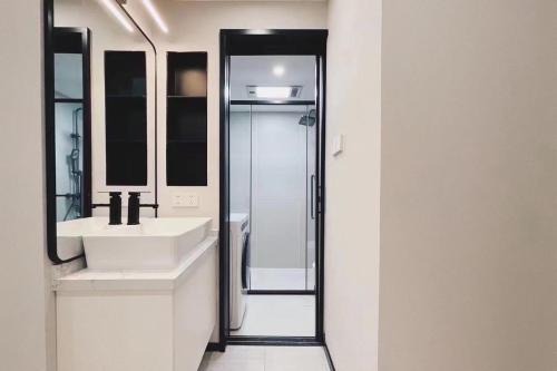ein Badezimmer mit zwei Waschbecken und einer Glasdusche in der Unterkunft EHUB - Nanjing Road 2Bedroom Apartment in Shanghai