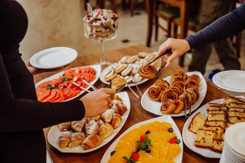 Una mesa llena de platos de comida con gente buscando comida. en Hotel Buczyński Medical & SPA, en Świeradów-Zdrój