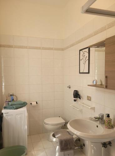 a white bathroom with a toilet and a sink at Da Sergio appartamento intero in Belgioioso