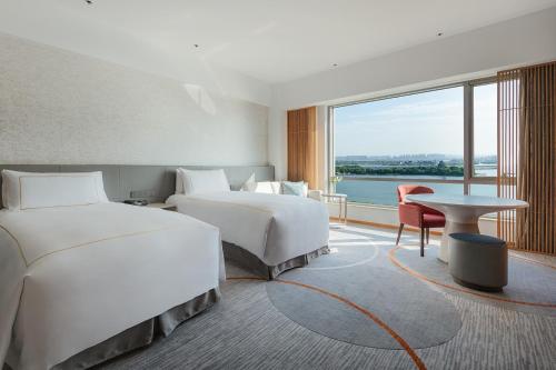 a hotel room with two beds and a large window at InterContinental Suzhou Hotel by IHG in Suzhou
