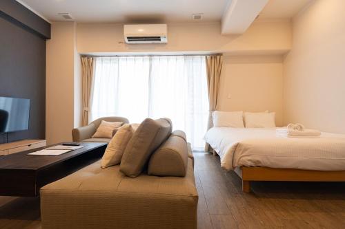 une chambre avec deux lits, un canapé et une télévision dans l'établissement PORTO7-5, à Chatan
