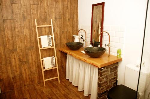 a bathroom with two sinks on a wooden counter at Chata na Zielonym Wzgórzu in Garcz