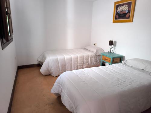 une chambre avec deux lits et une table avec une lampe dans l'établissement Casa Paulonia, à Las Negras