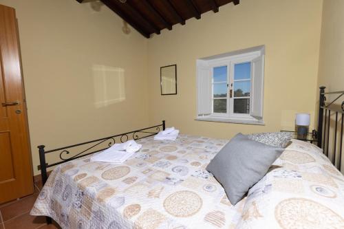 a bedroom with a bed and a window at La Dimora sul Lago in Castelvecchio