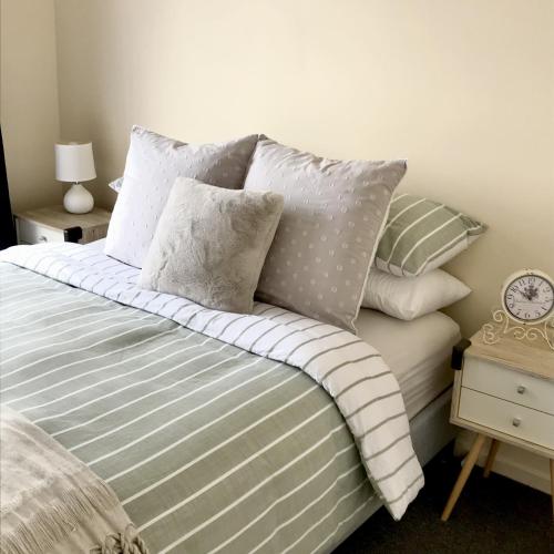 a bedroom with a bed with pillows and a clock at Lakeview Home in Toronto