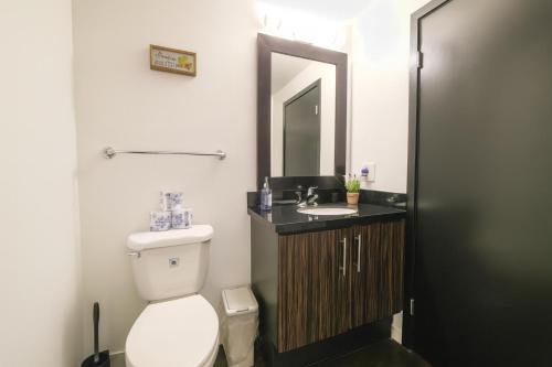 a bathroom with a toilet and a sink and a mirror at The Heart Of Hollywood Hills in Los Angeles