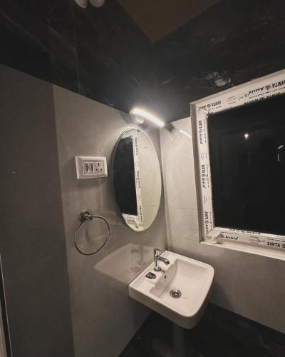 a bathroom with a sink and a mirror at Kodai paradise in Dindigul