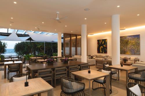 a restaurant with tables and chairs and a view of the ocean at Nyne Hotels Anuprit - Bentota in Bentota