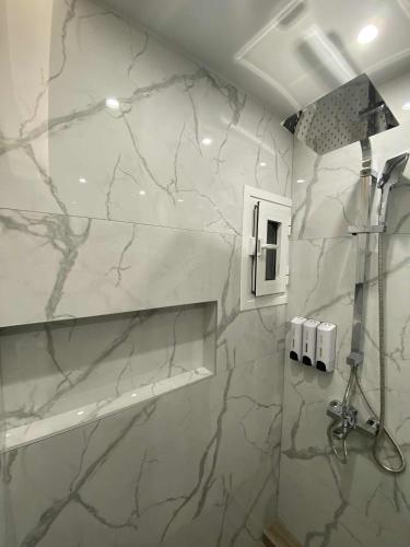 a bathroom with white marble walls and a shower at Cendream in Drama