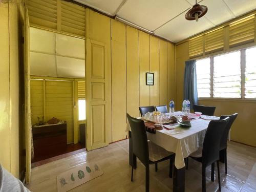 une salle à manger avec une table et des chaises noires dans l'établissement Rooma Rustic Homestay, à Kuala Kangsar