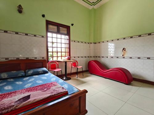 ein Schlafzimmer mit einem Bett und einem Tisch und Stühlen in der Unterkunft Nhà Nghỉ Mỹ Linh - Quảng Ngãi in Mỹ Lộc