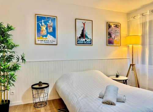 Un dormitorio con una cama y algunos cuadros en la pared. en Mountain Studio, en Cluses