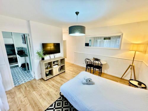 Una habitación con una cama, un televisor y una mesa. en Mountain Studio, en Cluses