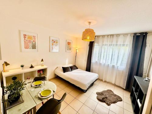 Un dormitorio con una cama y una mesa en una habitación. en Flowers Studio, en Saint-Julien-en-Genevois