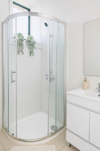 a white bathroom with a shower and a sink at Douro Vila 10 - Best View in Town in Bandeira