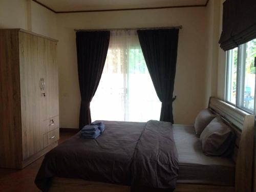 a bedroom with a bed and a large window at JS HOUSE Singha Park Chiang Rai in Ban Mae Kon