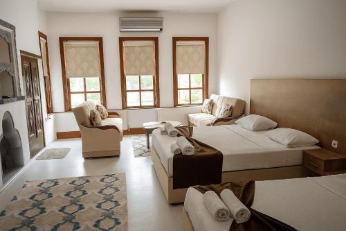 ein Schlafzimmer mit einem Bett, einer Couch und Stühlen in der Unterkunft Yörgüç Paşa Konağı Apart Otel in Amasya