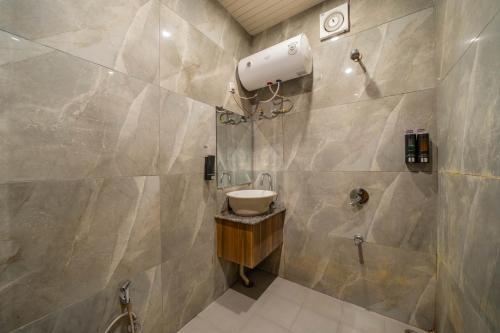 une salle de bain avec un lavabo et une douche dans l'établissement Perfectstayz Premium at Harkipauri Road - Ganga view rooftop cafe, à Haridwar