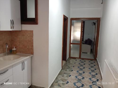 eine Küche mit einem Waschbecken und eine Tür zu einem Zimmer in der Unterkunft Yörgüç Paşa Konağı Apart Otel in Amasya