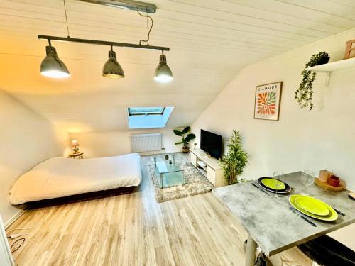 a bedroom with a bed and a table in a room at Le Chaleureux in Marignier