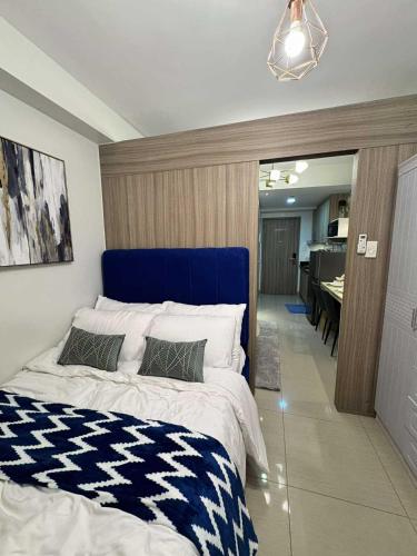 a bedroom with a large bed with a blue head board at Blisshaven SHORE 2 B03-14100 in Sampong